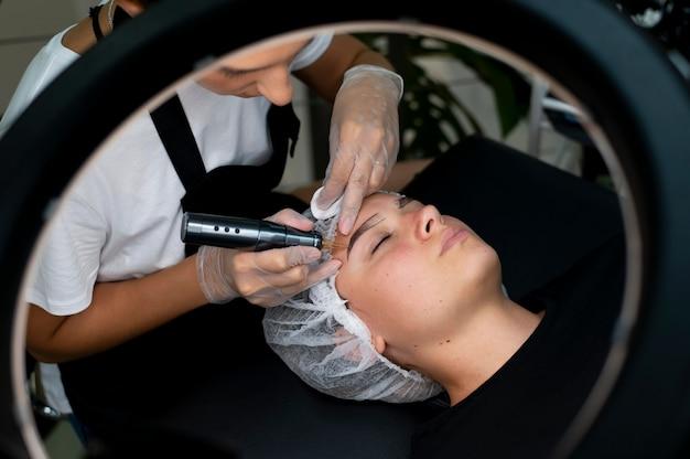 Skincare treatment with a professional beautician using a specialized tool for cosmetic eyebrow tattoo Melbourne